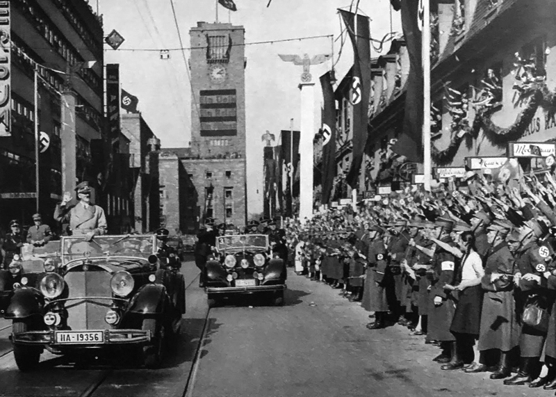 Adolf Hitler crosses Stuttgart and greets the crowd on his way to make a speech in the city hall